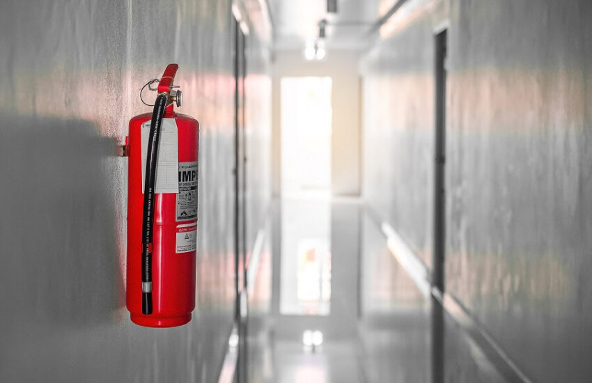 Extintor de incêndio instalado em corredor para segurança contra incêndios.