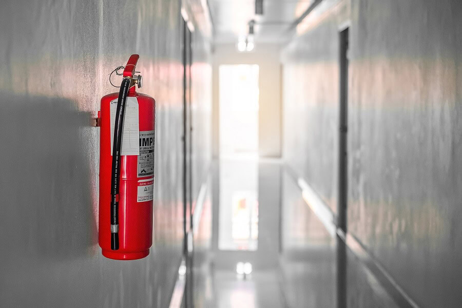 Extintor de incêndio instalado em corredor para segurança contra incêndios.