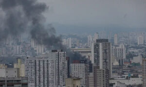 Incêndio em prédio no Brás, São Paulo, com fumaça preta saindo do edifício.