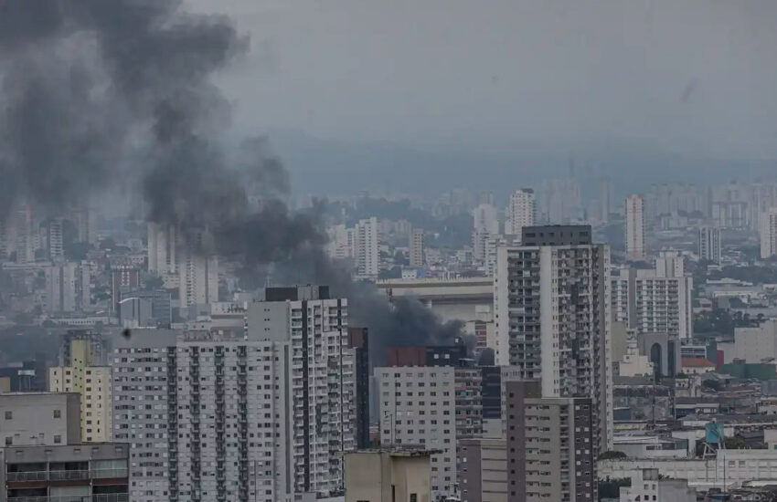 Incêndio em prédio no Brás, São Paulo, com fumaça preta saindo do edifício.