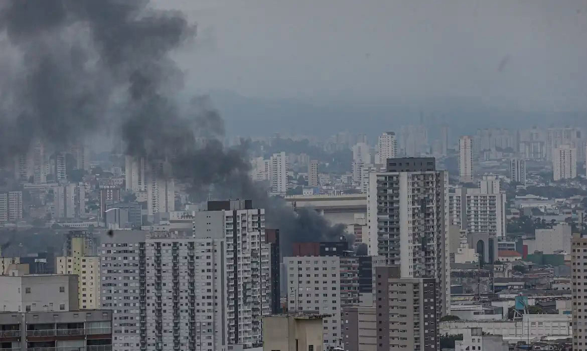 Incêndio em prédio no Brás, São Paulo, com fumaça preta saindo do edifício.
